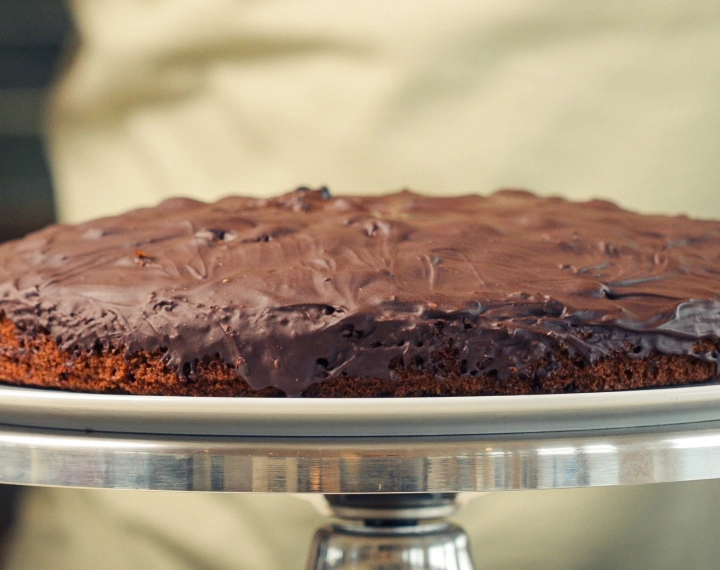 Hotový domácí cannabis space cake s rozpuštěnou hořkou čokoládou, podávaný jako klasický edible dezert